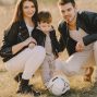 A family enjoys a warm day bonding and playing soccer outdoors in the park.